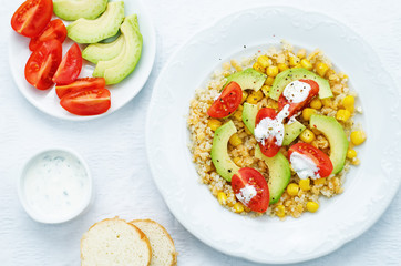 salad with quinoa, red lentils, corn, avocado and tomato with yo