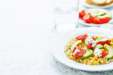 salad with quinoa, red lentils, corn, avocado and tomato with yo