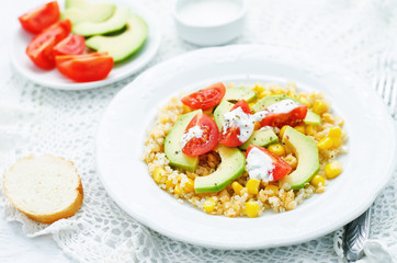 salad with quinoa, red lentils, corn, avocado and tomato with yo