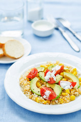 salad with quinoa, red lentils, corn, avocado and tomato with yo
