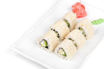 Three-cornered sushi roll with fish, cucumber and green salad.