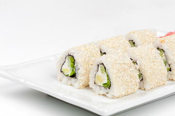 Three-cornered sushi roll with fish, cucumber and green salad.