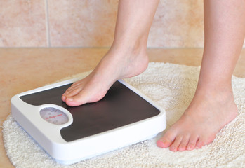 Woman's feet on bathroom scale. Diet concept