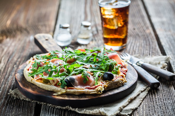Fresh pizza on paper and old wooden table