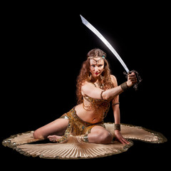 Beautiful belly dancer holding sword out