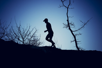 Silhouette of a man running with a blue background