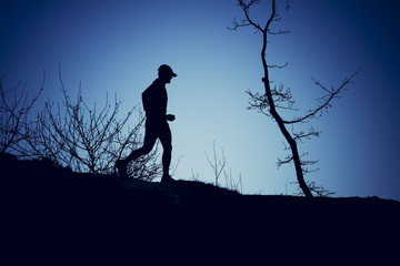 Silhouette of a man running with a blue background