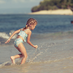 Fototapeta na wymiar little girl playing on the beach