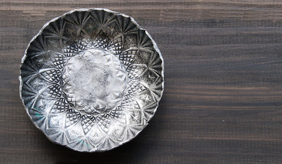 small textured metal plate on a wooden background