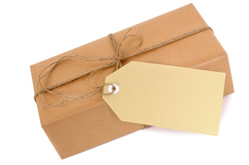 One single small brown paper wrapped package parcel or gift box with white string and tag isolated on white background photo