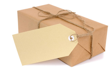 One single small brown paper wrapped package parcel or gift box with white string and tag isolated...