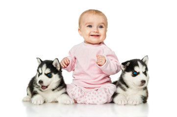 Little girl with two puppies husky