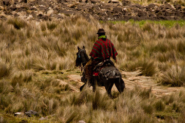 Local indigenous man riding a horse along the foothills of
