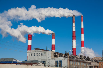 Smoking chimneys against the blue sky