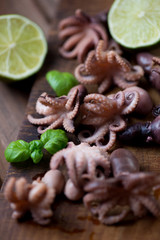 Close-up of baby octopuses with basil and lime, selective focus