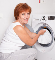 Woman puts clothes in the washing machine
