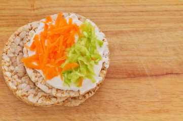 Rice cakes with white low fat cheese spread, carrot and cucumber