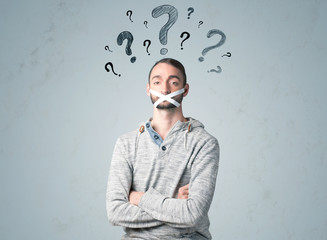 Young man with glued mouth and question mark symbols