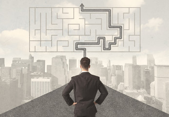 Businessman looking at road with maze and solution