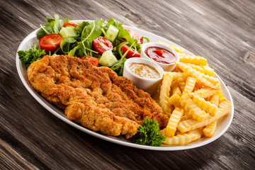 Fried pork chop, boiled potatoes and vegetable salad