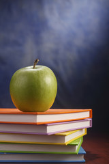 Books and an apple.