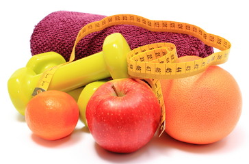 Fruits, tape measure, green dumbbells and towel on white