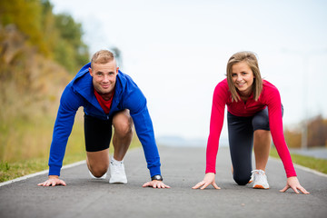 Urban leisure - woman and man ready to run