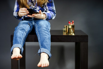 Cute little girl with mother's cosmetics, close-up portrait