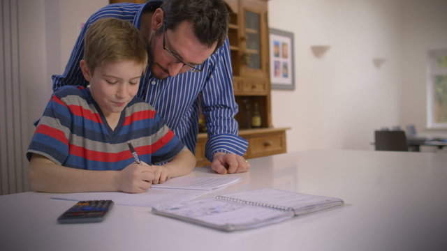 Father helps his young son with homework