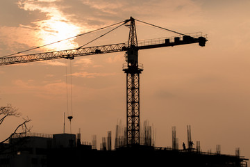 Industrial landscape with silhouettes of cranes on the sunset