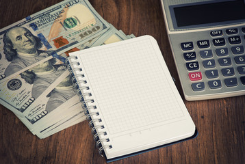 calculator and notepad lying on banknotes