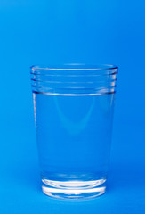 Glass of water over a blue background.