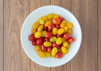 Red and yellow tomatoes in white bowl