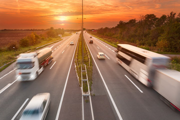 Truck and bus on the motorway at sunset © rasica