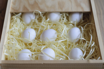 White eggs in a wooden box.