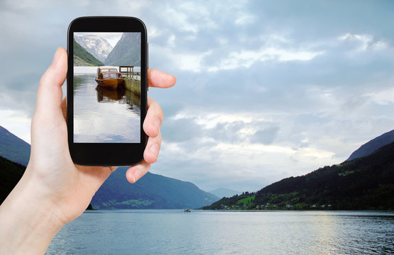 tourist taking photo of fjord in Norway in evening