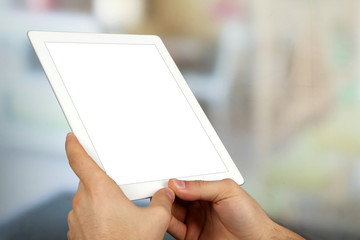 Hands using tablet PC on light blurred background