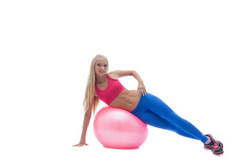 Smiling blonde posing exercising on fitness ball