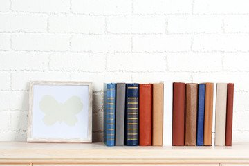 Fototapeta na wymiar Books on shelf on wall background