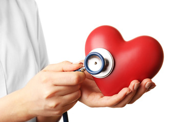 Doctor hands with heart and stethoscope isolated on white