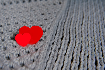 Fototapeta premium Handmade grey knitting wool texture background with red hearts