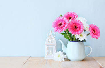 summer bouquet of flowers and vintage lantern on the wooden tabl