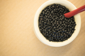 Fototapeta na wymiar black lentils in a porcelain cup close up