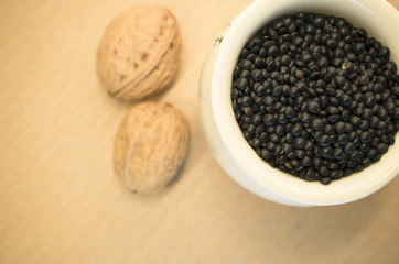 black lentils  in a porcelain cup and walnuts