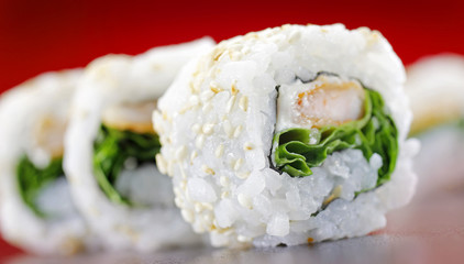 A close up shot of sushi dish uramaki with rocket salad