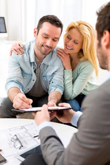 Young attractive couple signing contract with real estate agent - obrazy, fototapety, plakaty