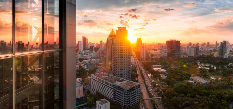 Bangkok city sunlight warm orange panorama, dawntime sunrise in morning rooftop view, the office buildings in Bangkok city  skyline top view business office in capital city of Thailand Asian 