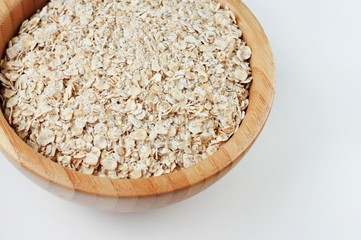 Wooden bowl of dry rolled oats