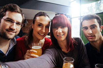 Group Of Friends In Tavern Taking Selfie