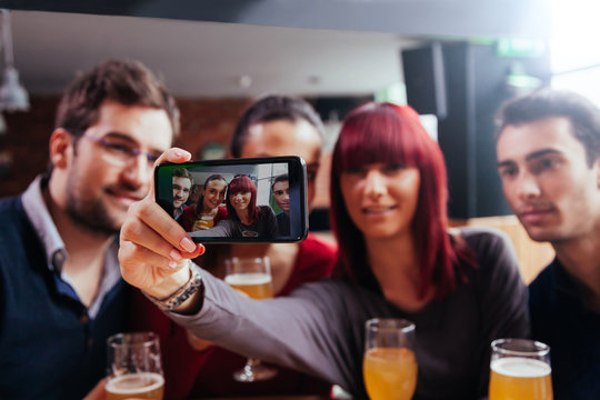 Group Of Friends In Tavern Taking Selfie